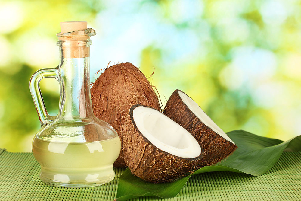 Kokosöl in Flasche mit Kokosnuss