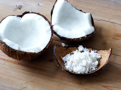Kokosnusshälften mit Kokosflocken