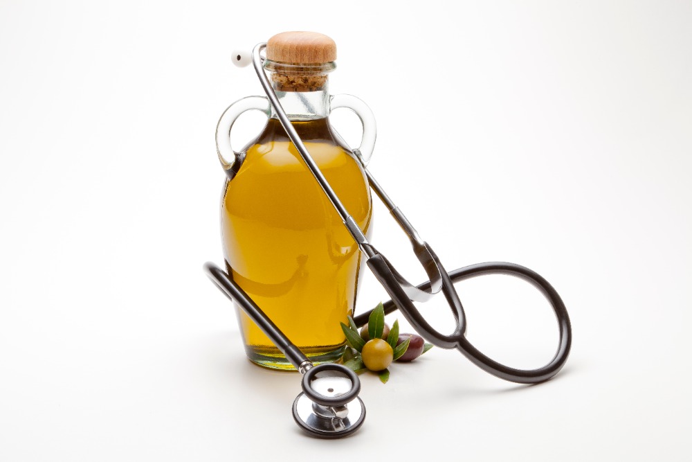 Olivenöl in Glasflasche mit Stetoskop